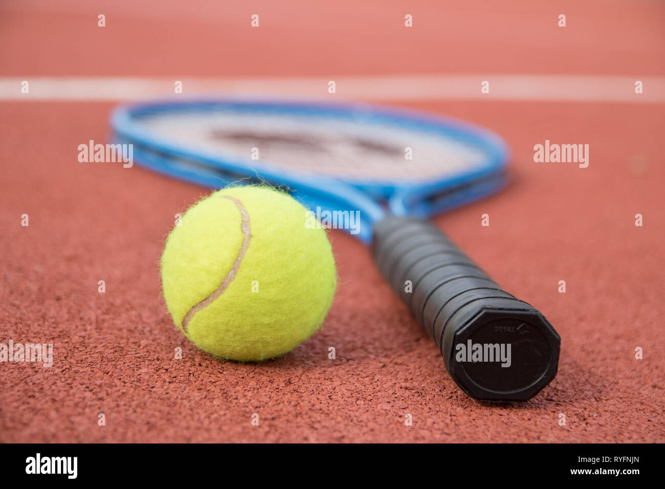 Balle de tennis jaune et racket sur surface dure ligne blanche close-up Banque D'Images