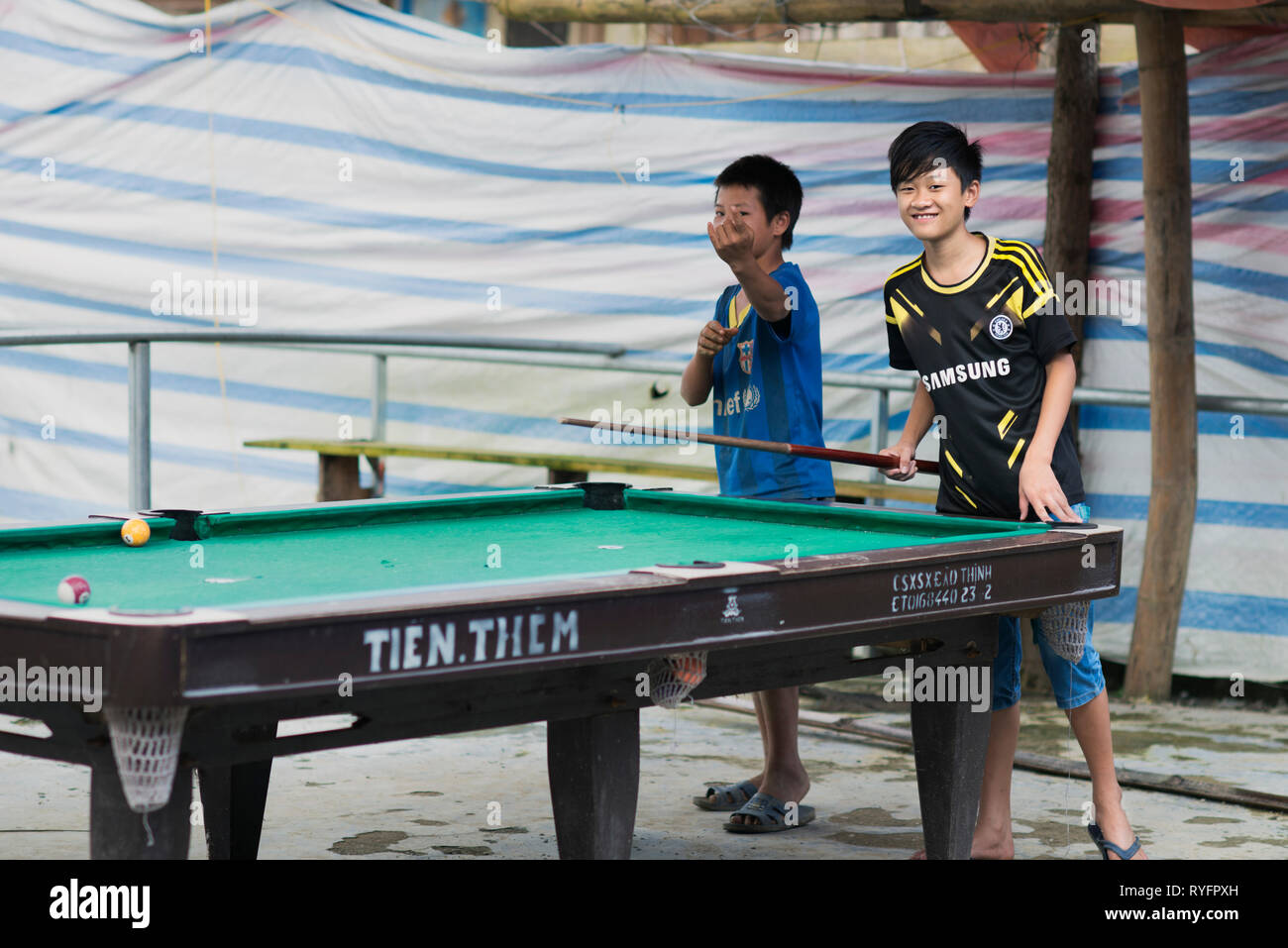 Deux adolescents jouant au billard avec soccer Chelsea shirt jersey à Lao Cai, Vietnam Banque D'Images
