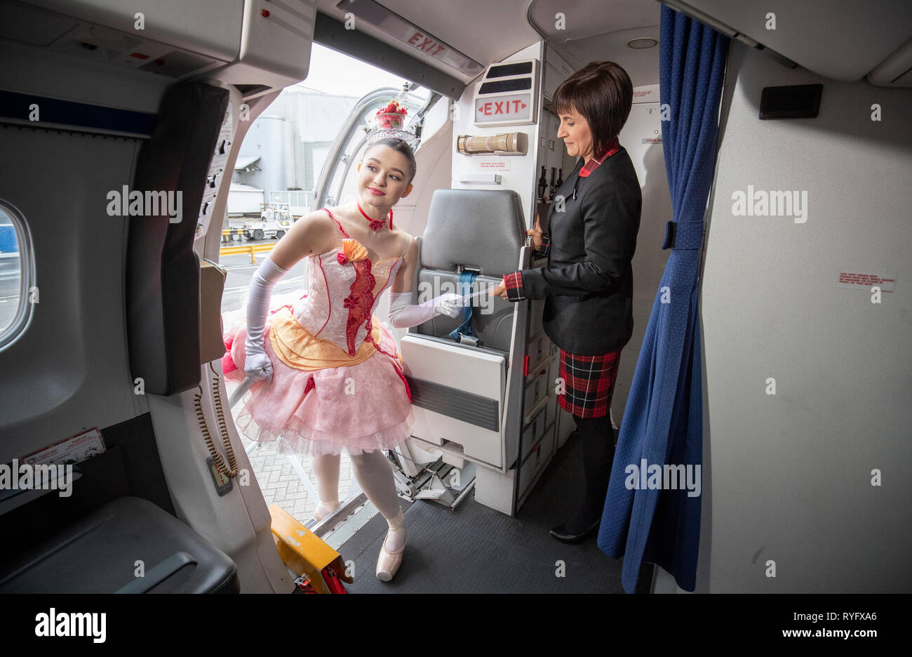 Kawalek Alice danseuse de ballet écossais entre dans un avion d'embarquement de caractère comme elle rencontre hôtesse Loganair Lynne Smith (à droite) lors d'un photocall à l'aéroport de Glasgow en avance sur leur tournée de highland fling 'Wee Hansel & Gretel'. Banque D'Images