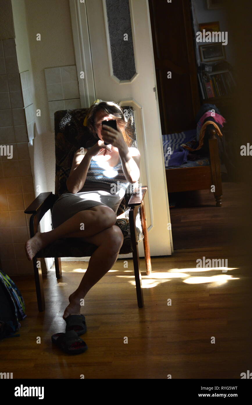 Femme au foyer avec smartphone Banque D'Images