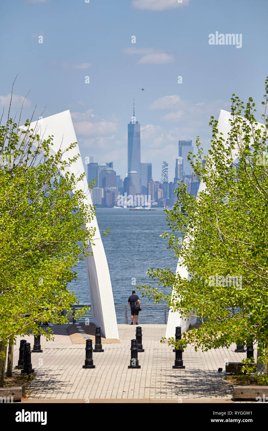 New York, USA - 29 juin 2018 : l'homme se tient entre les cartes postales, Staten Island le 11 septembre avec Memorial Manhattan à distance. Banque D'Images