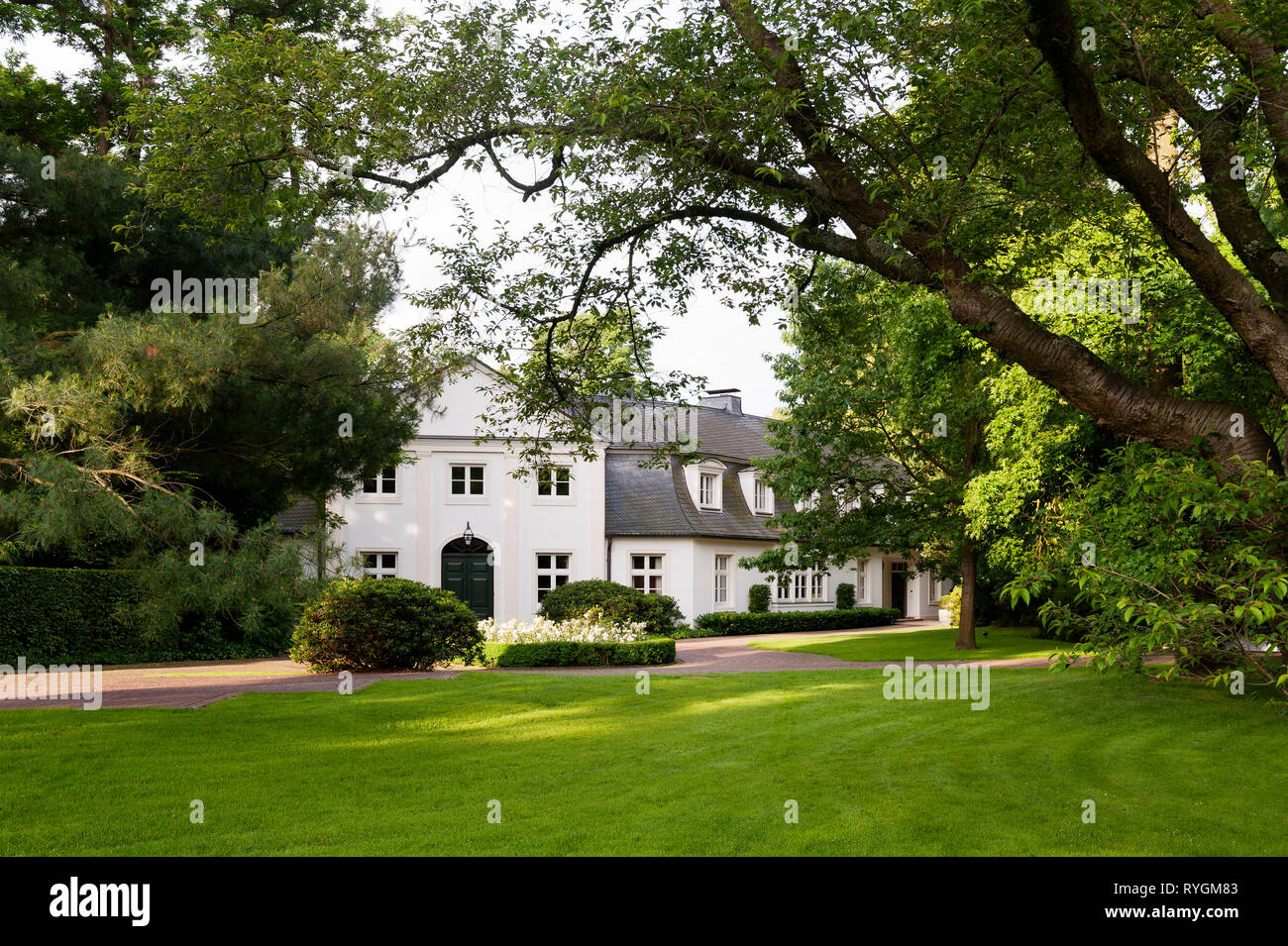 Pelouse et arbres par le colonial house Banque D'Images