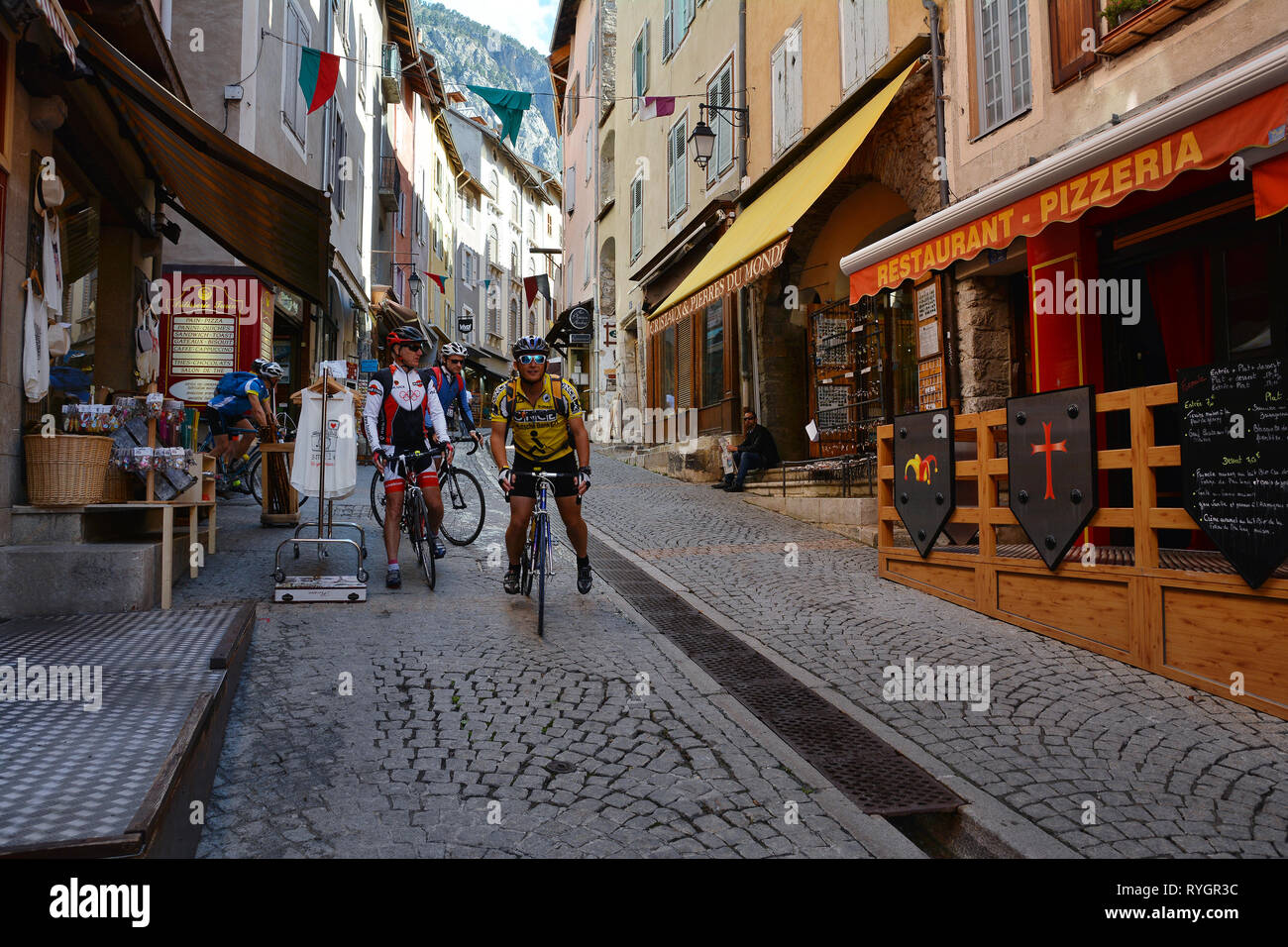 Les cyclistes au cours de Tour de France dans la vieille ville de Briançon, la ville la plus haute de France , station de ski populaire en hiver. Banque D'Images