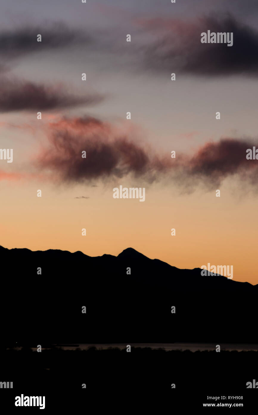 Ciel coucher de soleil romantique vue tranquillité contre silhouette de montagne Banque D'Images