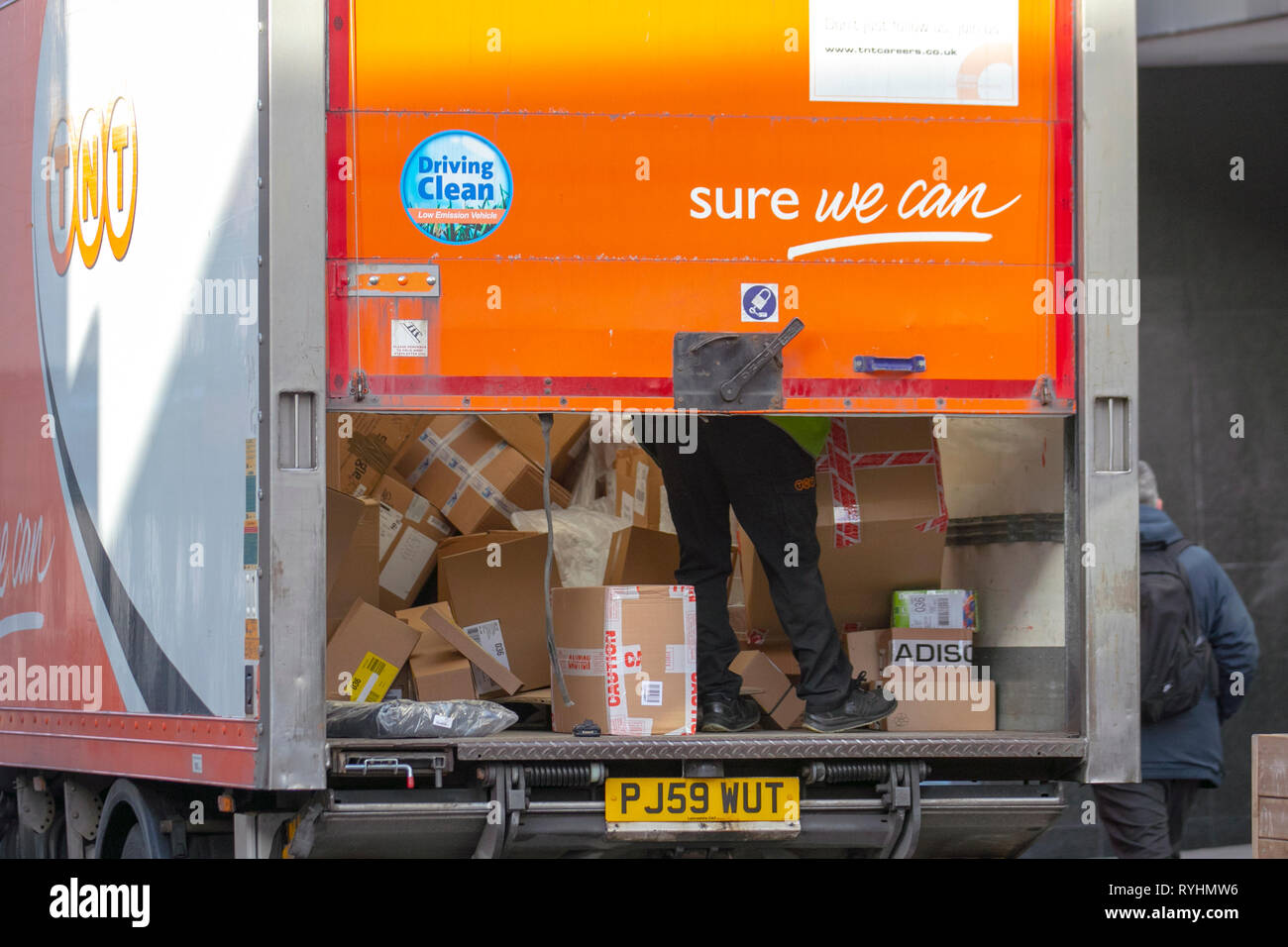 Livraisons de colis du service de messagerie TNT. Chargement complet de colis écrasés culbutés ; boîtes en carton livrées dans le centre-ville de Preston, livraison «sûr que nous pouvons». Banque D'Images