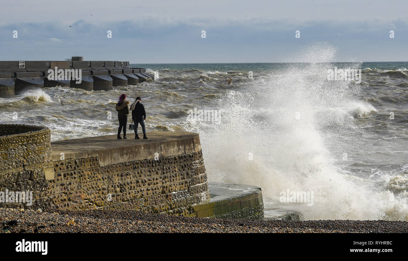 Brighton, UK. 14Th Mar, 2019. Passants regarder les vagues se briser en par le port de plaisance de Brighton sur la côte sud de la Grande-Bretagne, en tant que la queue du verglas Gareth quitte le Royaume-Uni Crédit : Simon Dack/Alamy Live News Banque D'Images