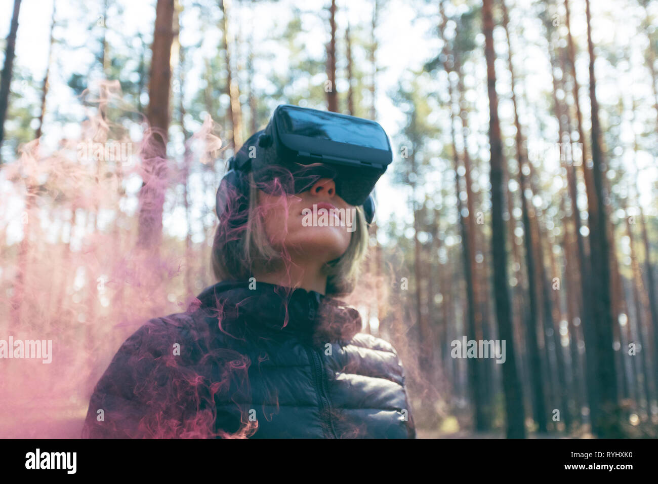 Une femme portant des lunettes de réalité virtuelle dans la forêt voit des bombes de fumée. Lunettes VR. Banque D'Images