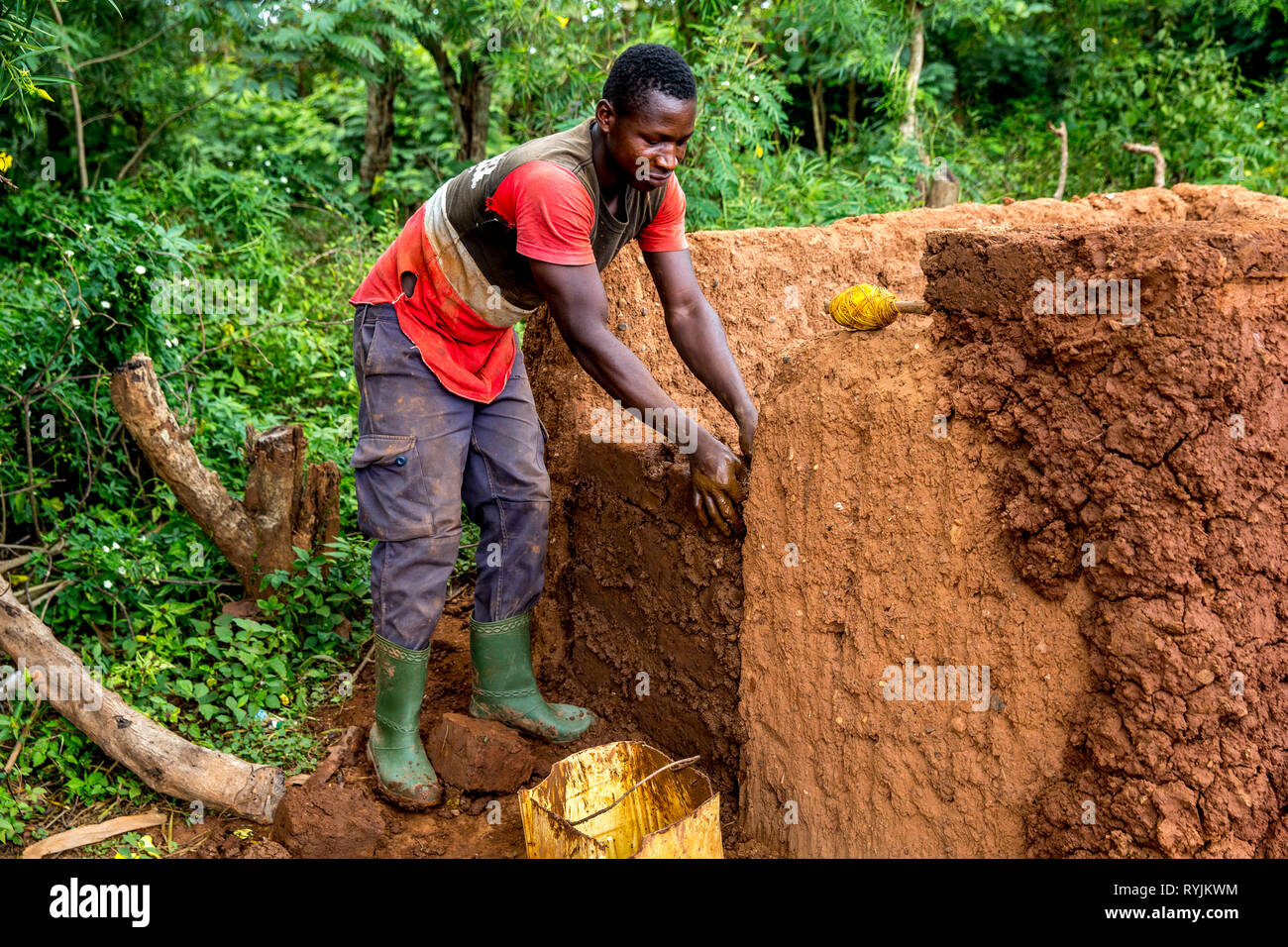 L'homme l'édification d'une maison de terre dans un village près de Daloa, Côte d'Ivoire. Banque D'Images