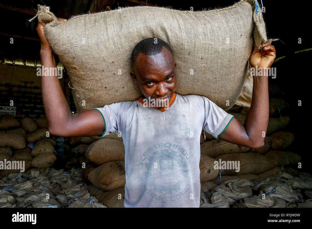 Travailleur de cacao portant un sac dans Abidjan, Côte d'Ivoire. Banque D'Images