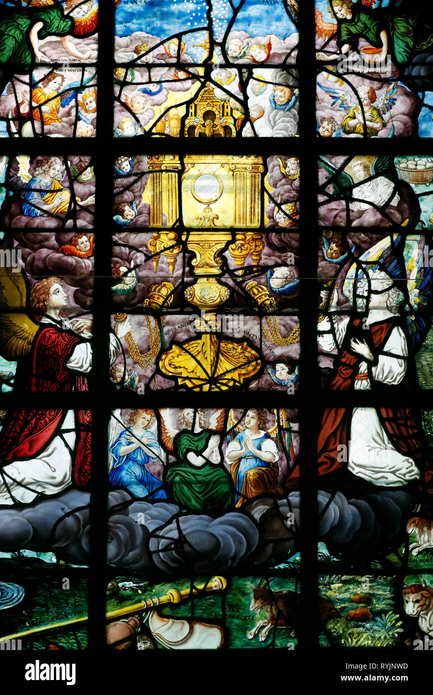 Saint Etienne du Mont church. Vitrail. L'Adoration de l'hôte. Un ostensoir holding l'hôte entouré par des anges et divers emblèmes. Banque D'Images