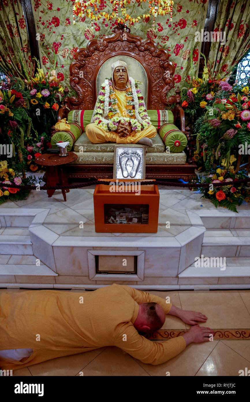 Prosternating dévot devant la statue de Swami Prabhupada, fondateur de l'Association internationale pour la conscience de Krishna (ISKCON), dans le temp Banque D'Images