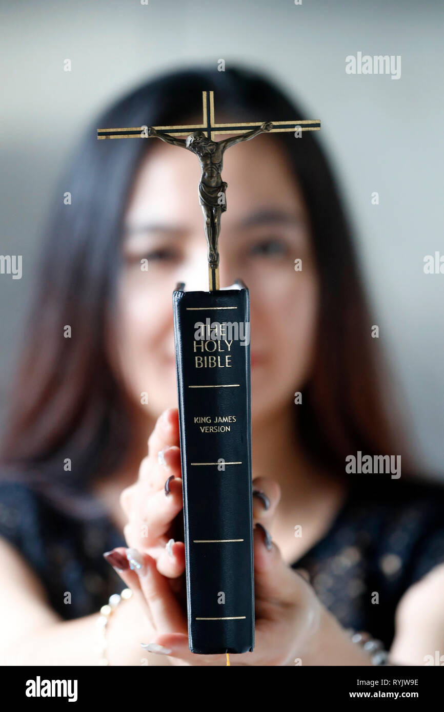 Femme catholique à la Sainte bible et un crucifix. Le Vietnam. Banque D'Images