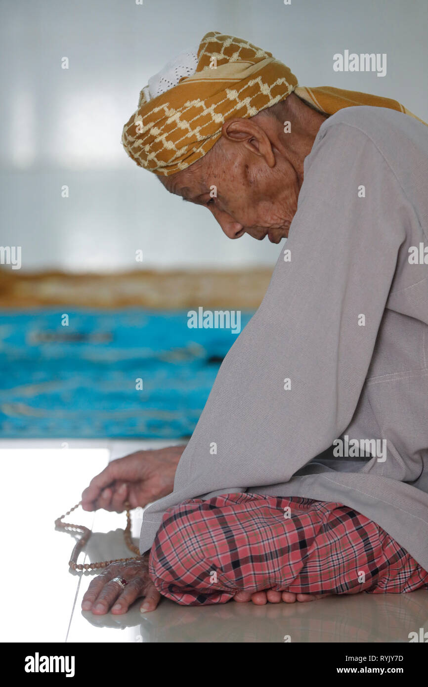 Mosquée Masjid Nia'mah. Muslim man holding Islamic Prayer beads. Chau Doc. le Vietnam. Banque D'Images