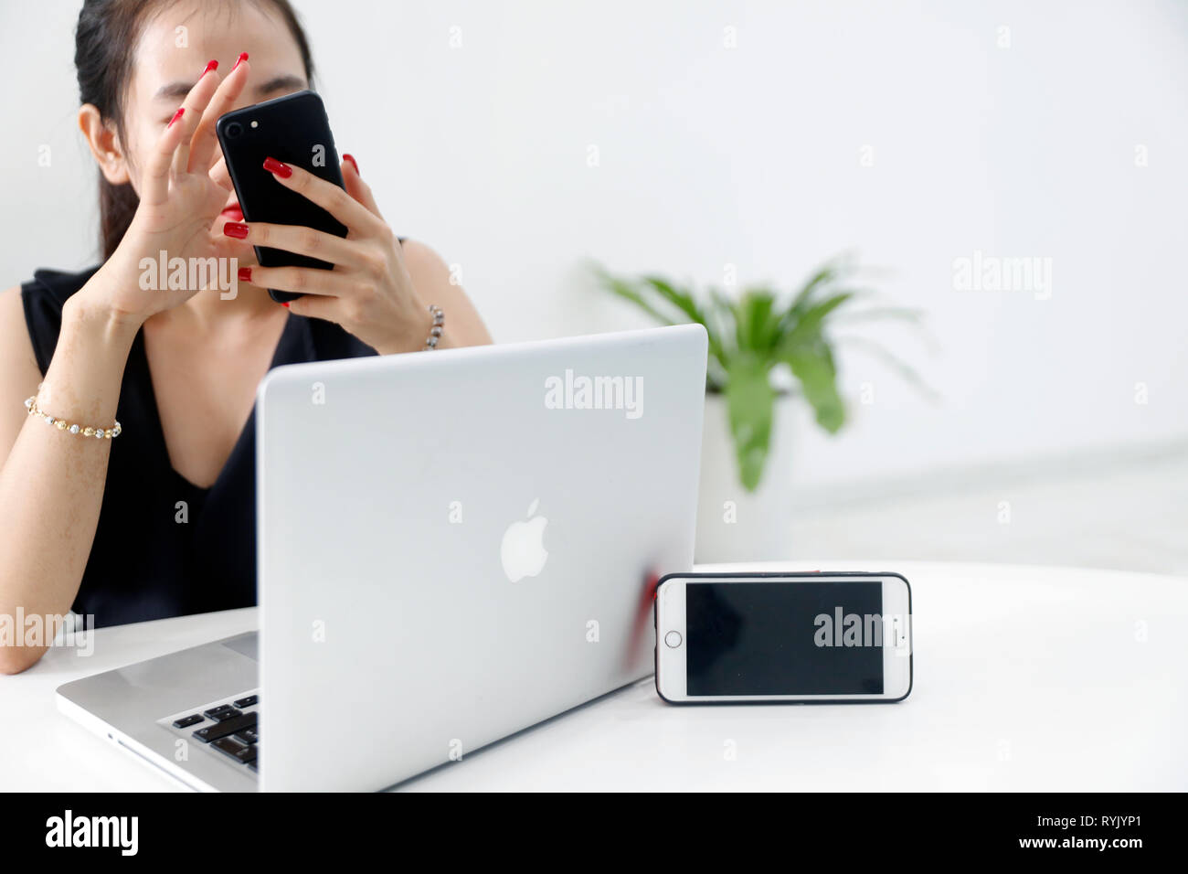 Femme avec le smartphone et l'ordinateur portable. Iphone et Mac Book. Ho Chi Minh Ville. Le Vietnam. Banque D'Images