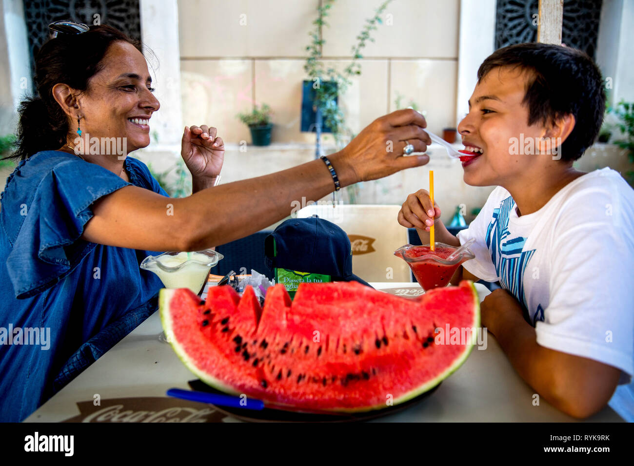 Mère et son eating watermelon à Palerme, Sicile (Italie). Banque D'Images