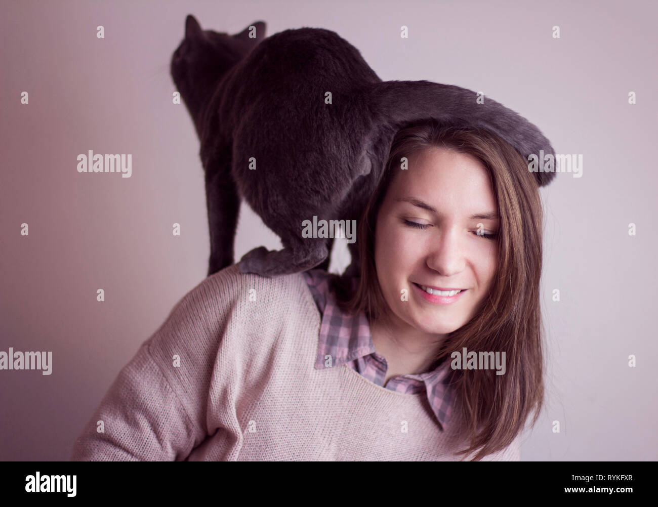 Femme avec son drôle de chat assis sur ses épaules Banque D'Images