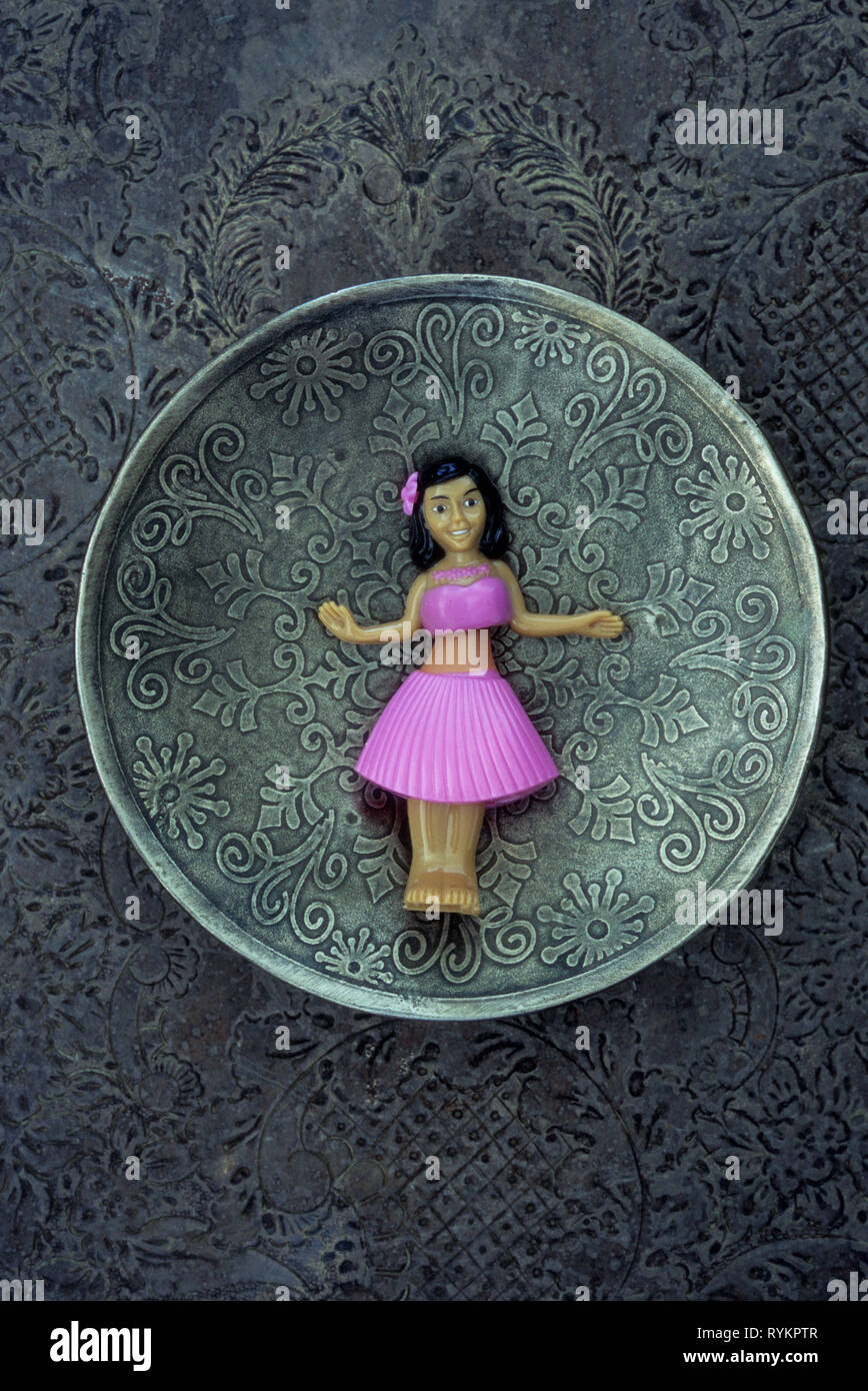 Modèle en plastique de fille en jupe rose et page faire danse huila situé sur la plaque d'argent à motifs Banque D'Images