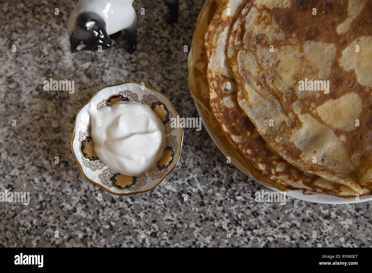 Les crêpes de crème de table kithcen et un chat statue en porcelaine Banque D'Images