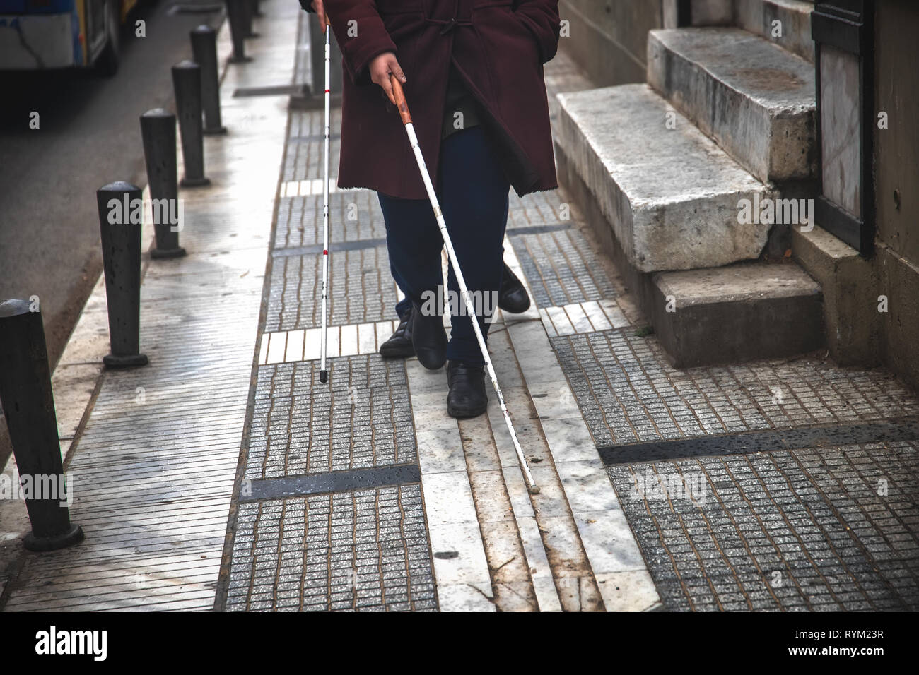 Blind man and woman walking on the street en utilisant une canne blanche Banque D'Images