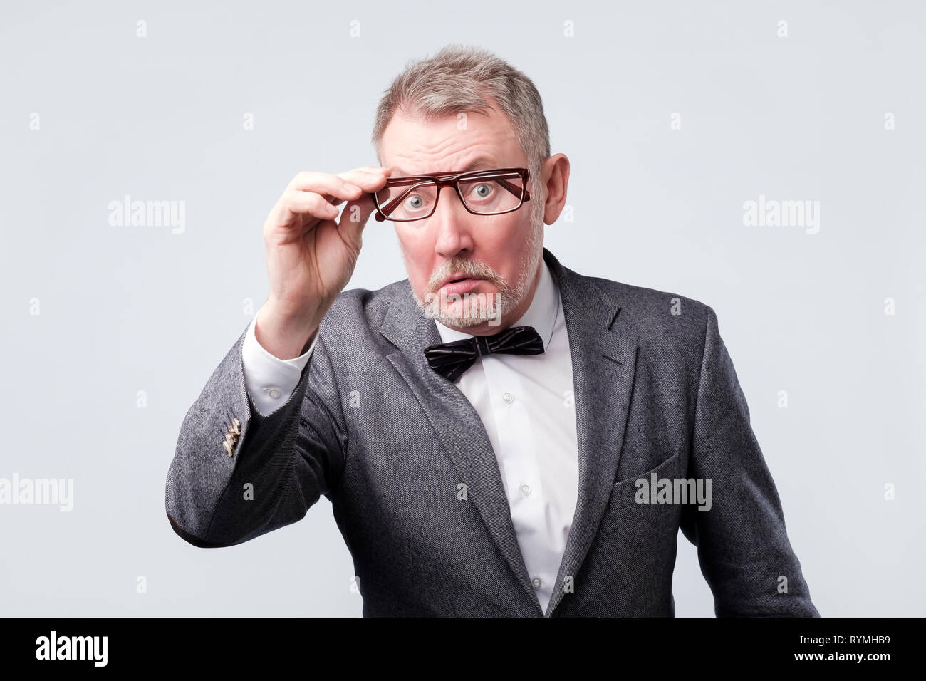 Senior man in suit lunettes de réglage les essayant. Banque D'Images