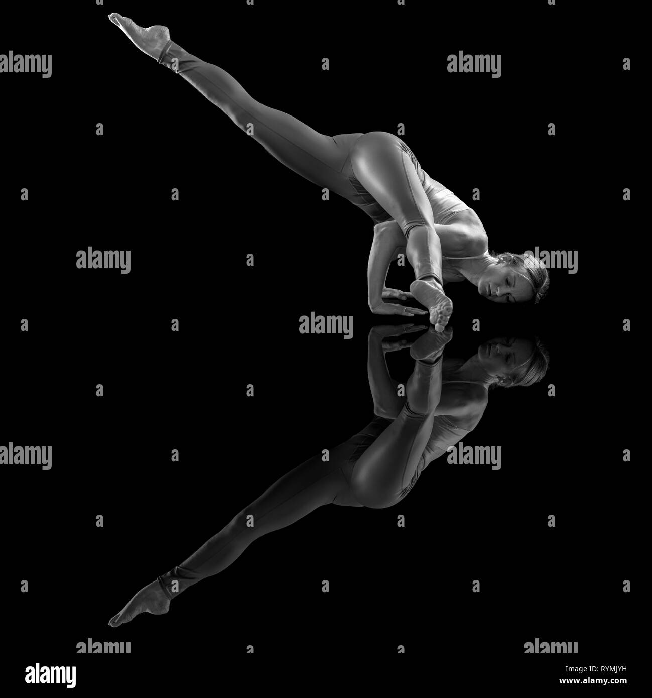 Femme faire un "Flying Lizard' yoga pose avec réflexion Banque D'Images