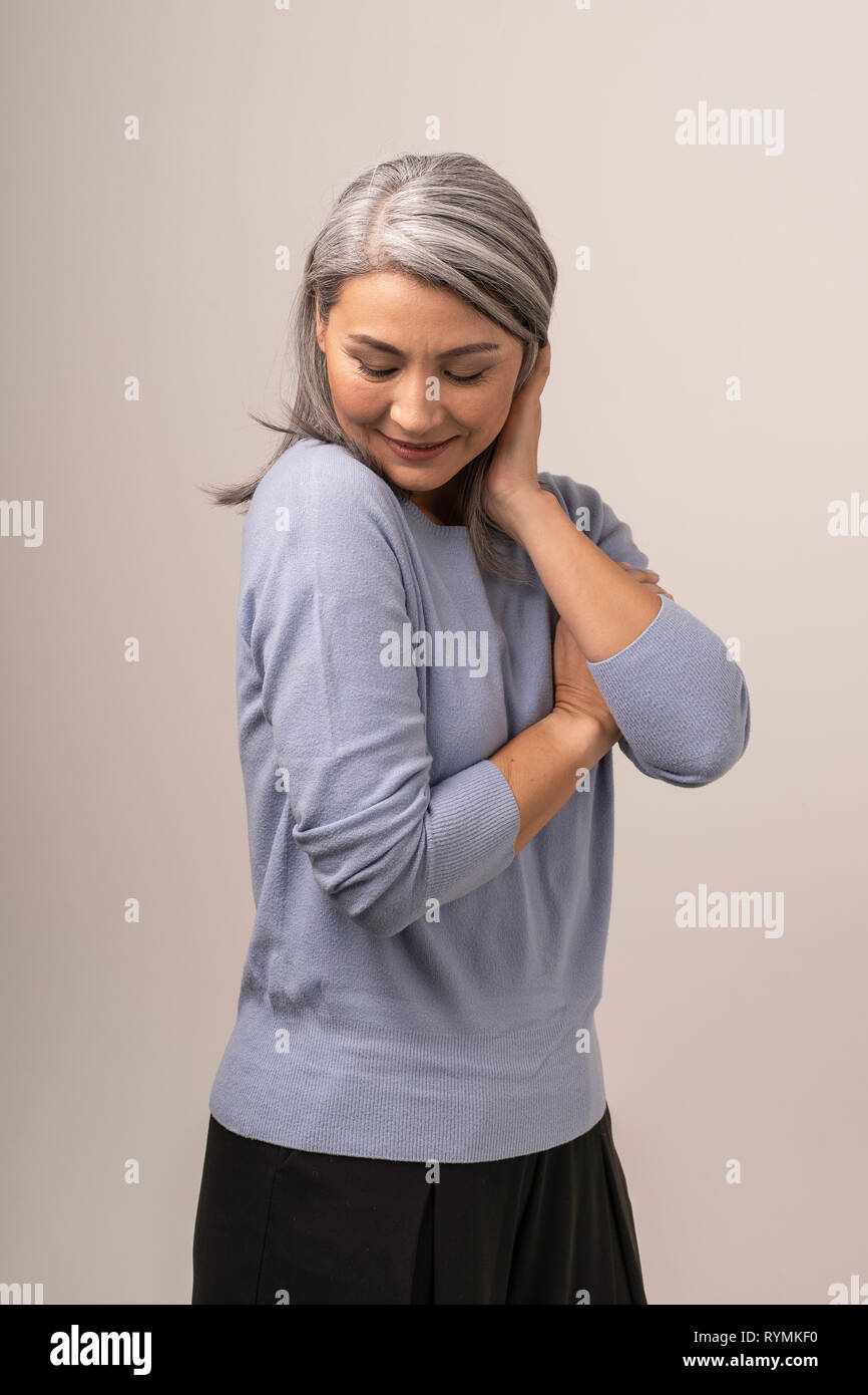 Happy woman hugging est elle-même sur fond blanc Banque D'Images