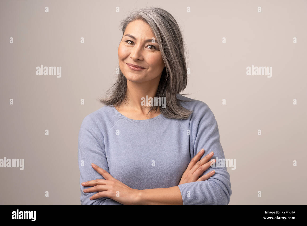 Smiling Asian woman with crossed arms Banque D'Images