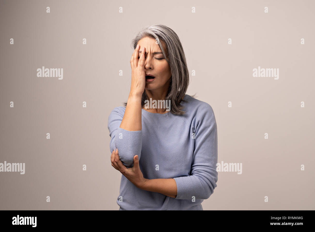 Asian woman covering her face with hand on white background Banque D'Images