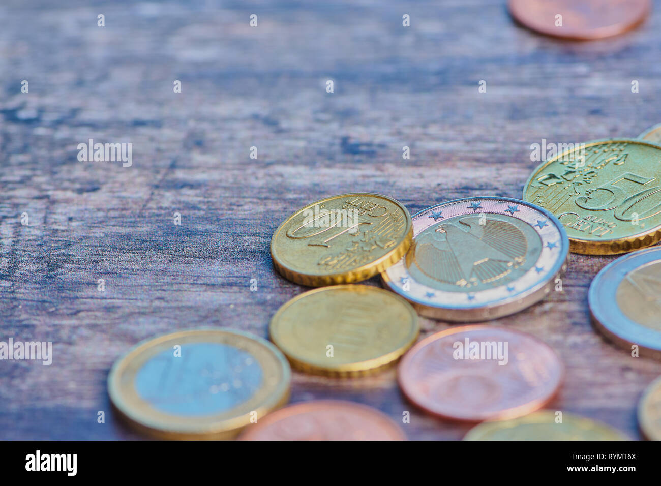 Peu de pièces en euro et cents sur une surface en bois brun, macro photo couleur with copy space Banque D'Images