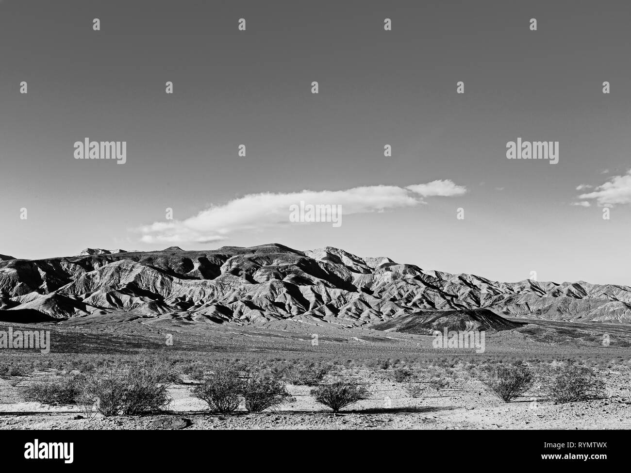 Désert de sable vallée avec pinceau mort montagnes arides et rocheux au-delà. Noir et blanc. Banque D'Images