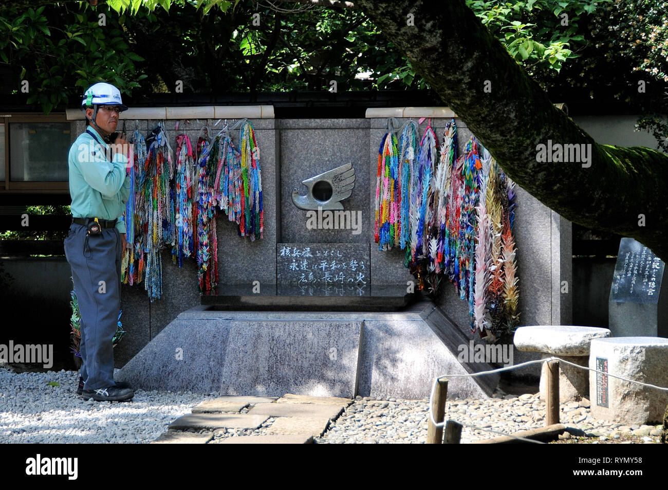 Parc Ueno, TOKYO, JAPON - Juillet 9, 2018 : un travailleur debout à côté de la CND Peace monument à Ueno Park, tandis que le jeûne son casque à Tokyo au Japon Banque D'Images