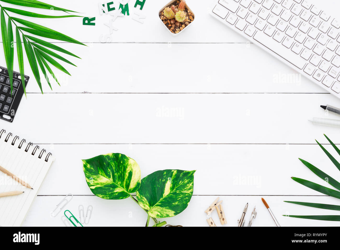 Haut voir le tableau 24. Avec l'espace de table, y compris l'arrêt de l'ordinateur portable sans fil, keybook, stylo, calculatrice, pothos doré et de feuilles de palmier sur Banque D'Images