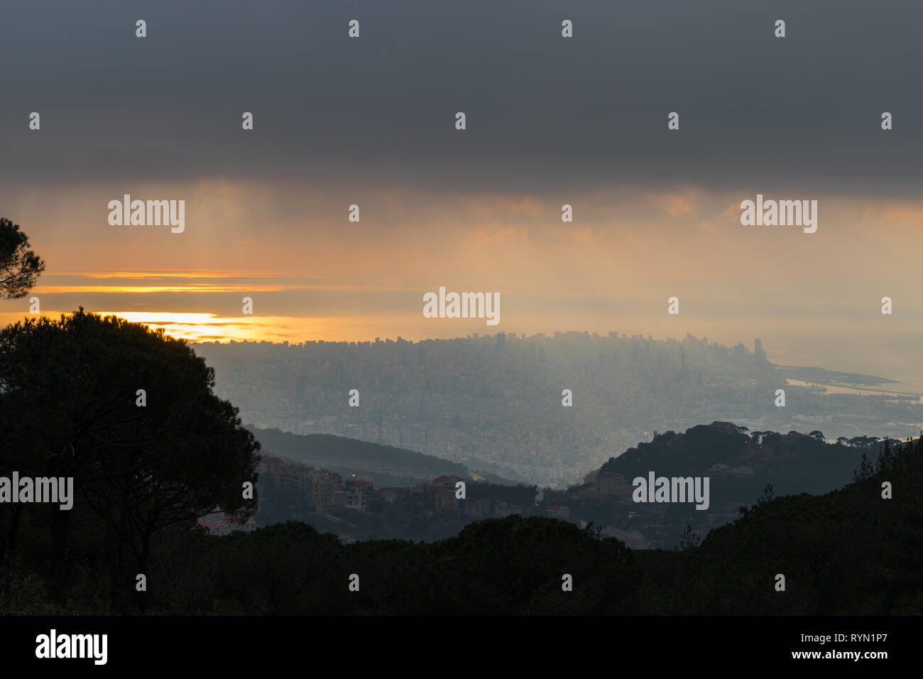 C'est une capture du coucher du soleil à Beyrouth capitale du Liban avec une couleur orange recouverte d'un brouillard épais et quelques nuages de pluie Banque D'Images