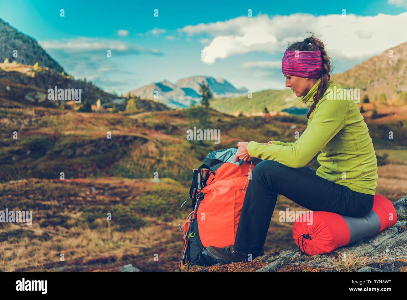 Départ Arrêt de repos. Young Caucasian Woman avec sac à dos sur le sentier alpin. L'heure d'été à la randonnée. Banque D'Images