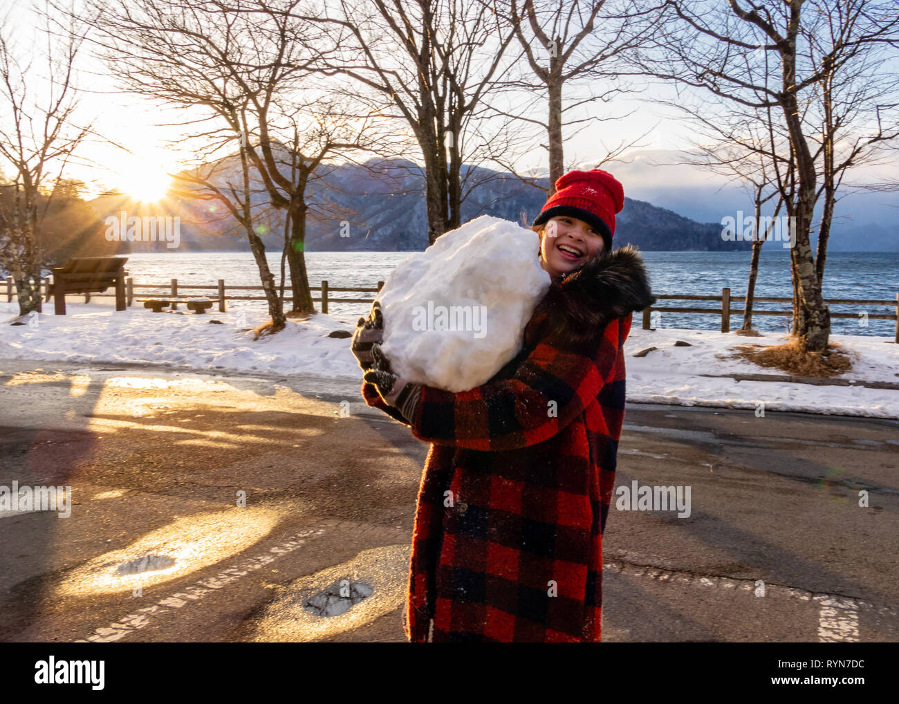 Jeune fille avec boule géante au lac Banque D'Images