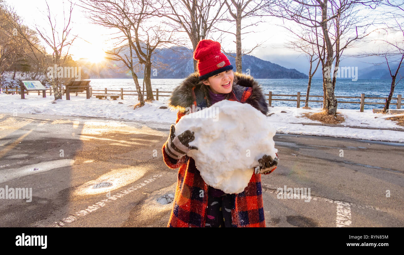 Jeune fille avec boule géante au lac Banque D'Images