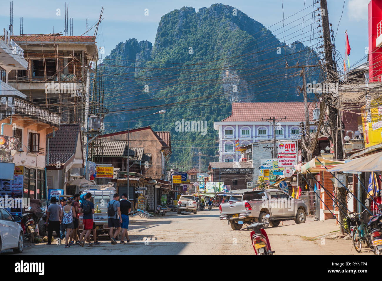 Vang Vieng, Laos - 28 décembre 2018 : l'une des principales rues de la ville avec toutes sortes d'entreprise touristique et une grande montagne en arrière-plan. Banque D'Images