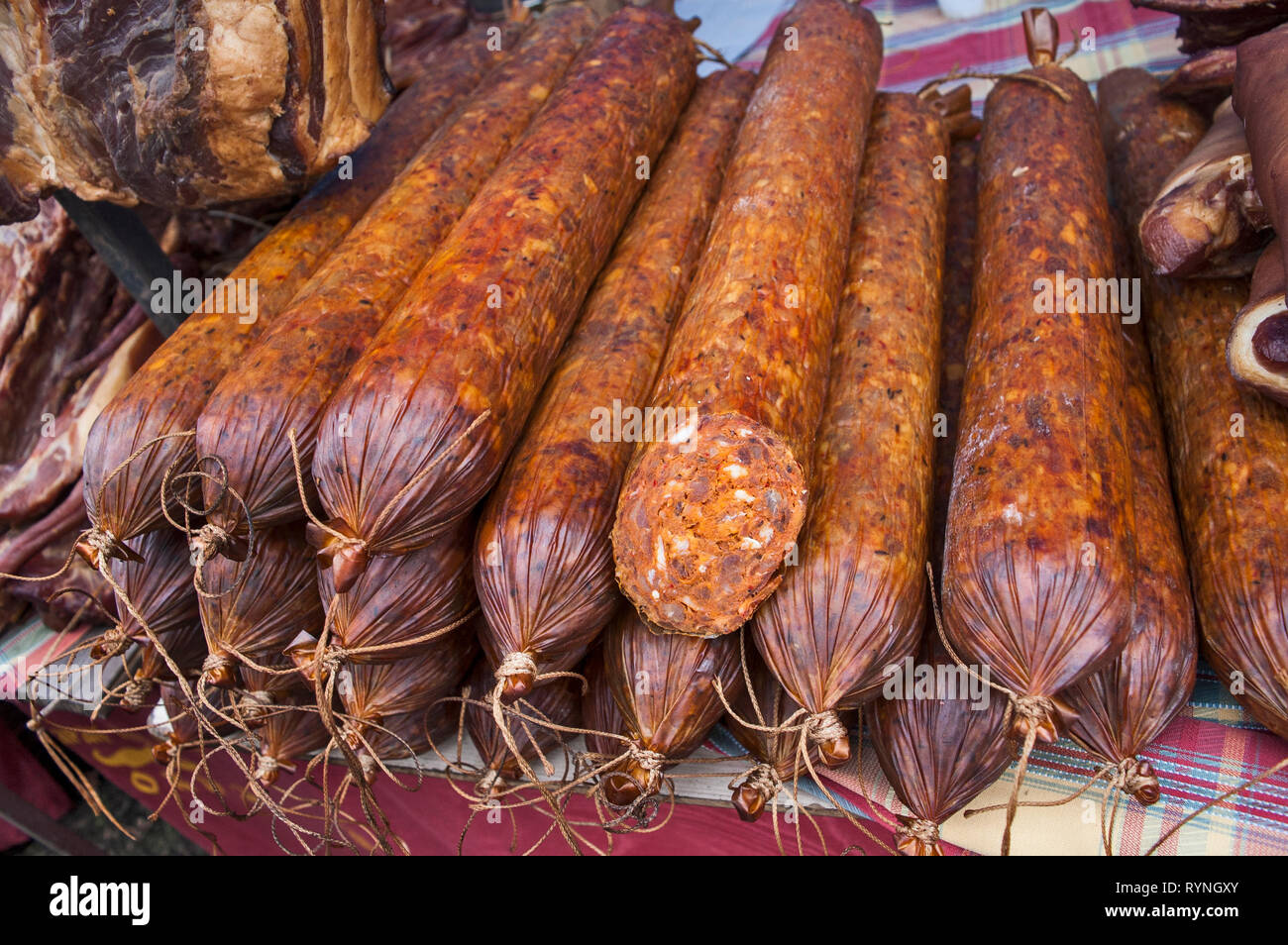 Des saucisses fumées et séchées et autres produits se distinguent sur la table pour la vente. Banque D'Images