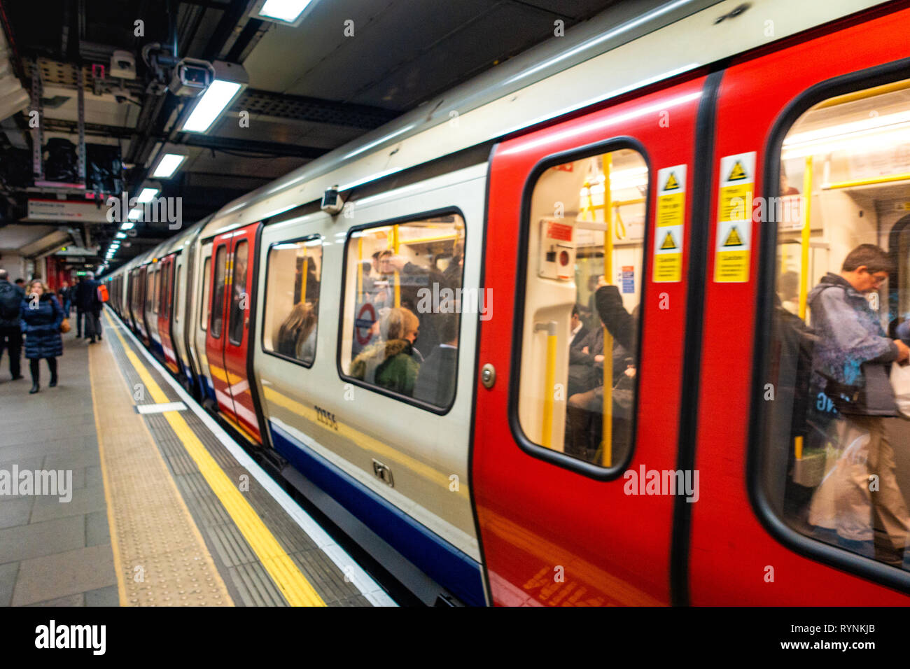 Tube de Londres train quitte la plate-forme à un endroit tranquille du temps de déplacement, après la fermeture des portes Banque D'Images