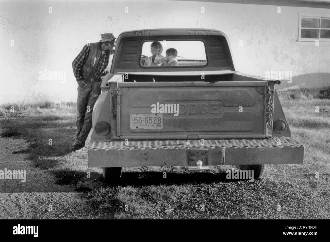 Butte Montana USA 1970 USA Père appuyé contre famille pick up truck de parler à ses enfants en attendant que sa femme d'arriver sur le bus Greyhound. 1971-NOUS HOMER SYKES Banque D'Images