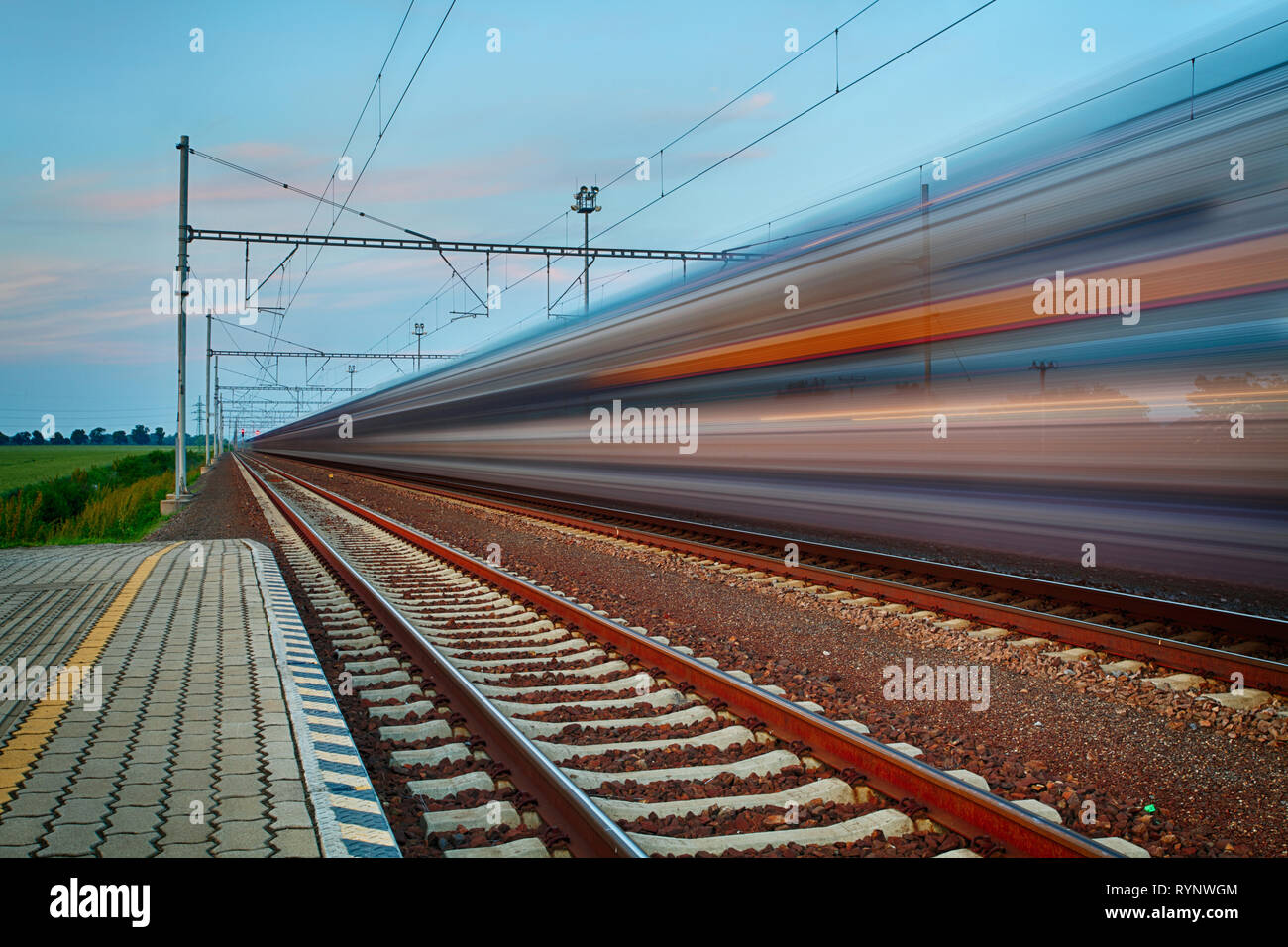 Voyages et transport ferroviaire du concept d'entreprise de l'industrie : nuit d'été de grande vitesse ferroviaire Le train au départ de la plate-forme Banque D'Images