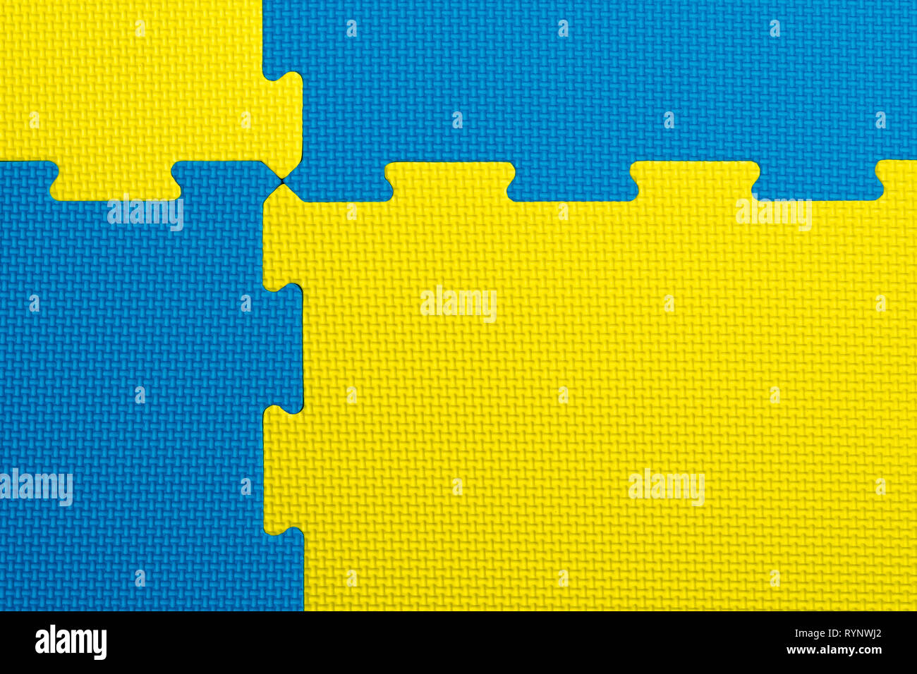 Bleu entrelacées et de mousse jaune à l'intérieur de carreaux d'une salle de sport, crèche, salle de jeu ou l'école. Utilisation potentielle comme un fond coloré avec copie espace. Banque D'Images