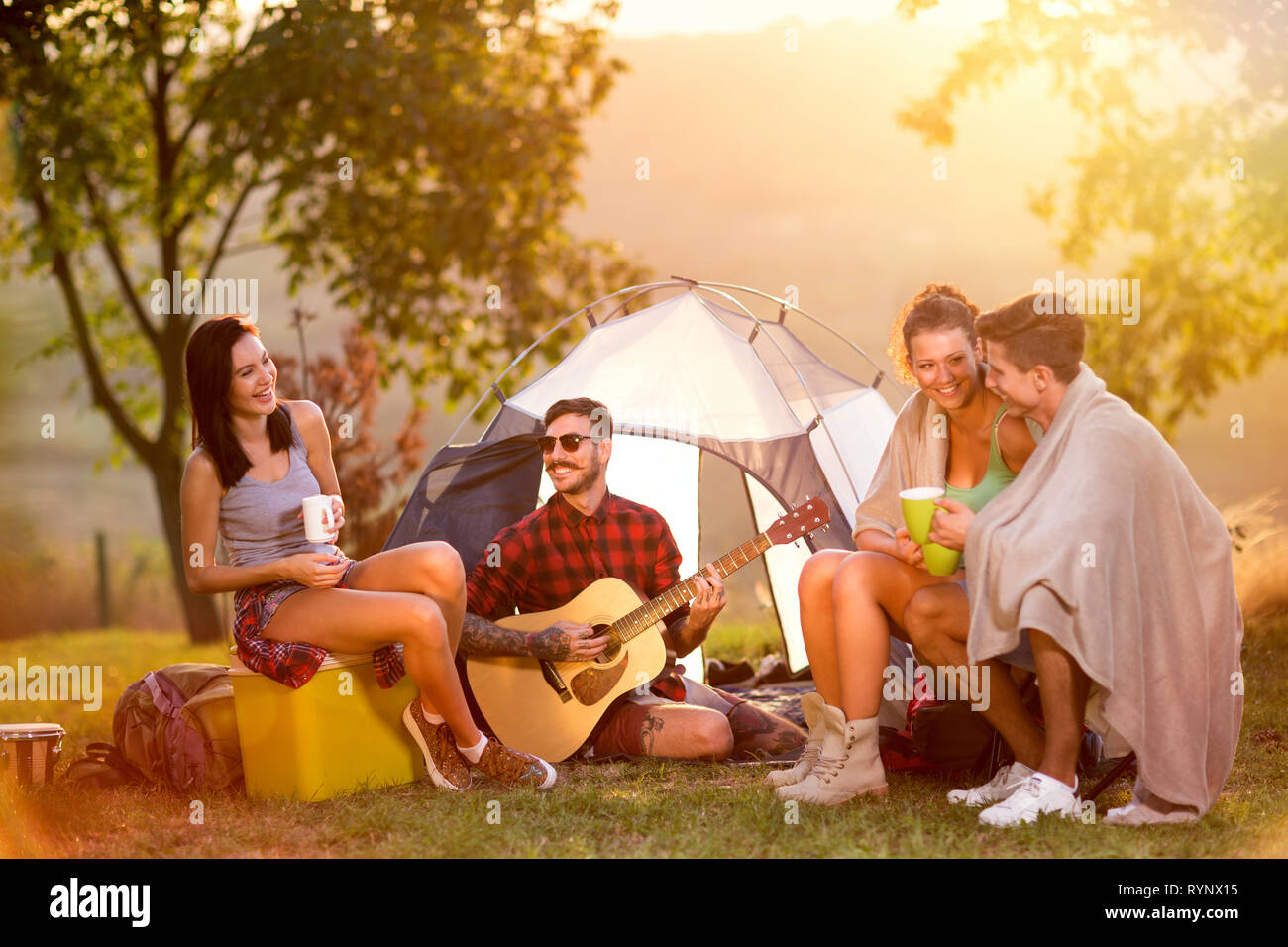 Ami en vacances camping tente garçon écoute jouer de la guitare Banque D'Images