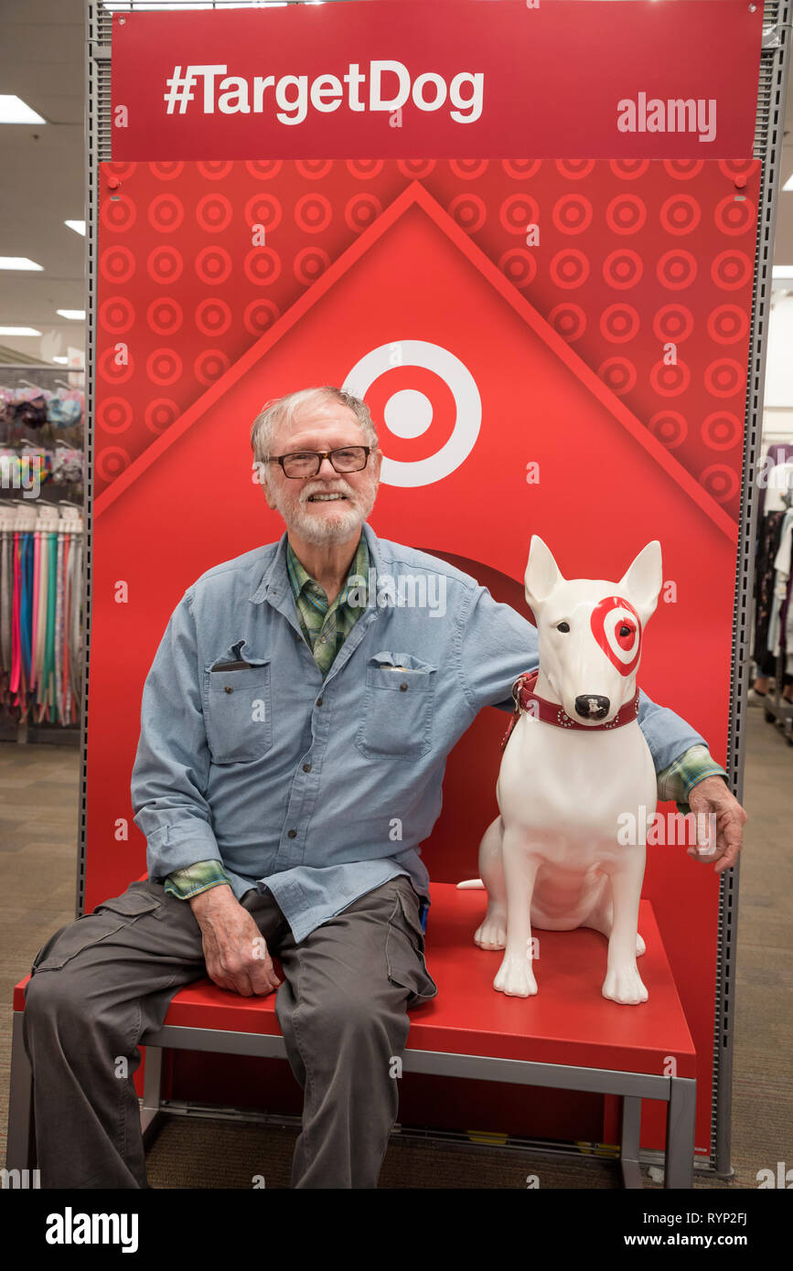 Homme posant avec un chien cible cible en magasin. Banque D'Images