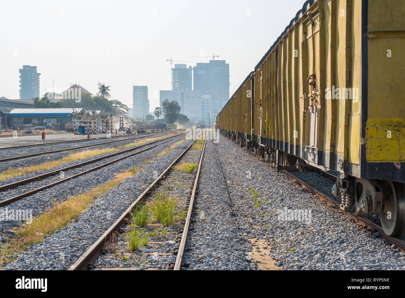 Phnom Penh, Cambodge - Le 25 janvier 2019 : un train de marchandises à la Gare de Phnom Penh avec la construction massive (un panneau 'Gateway') dans l'arrière-plan. Banque D'Images