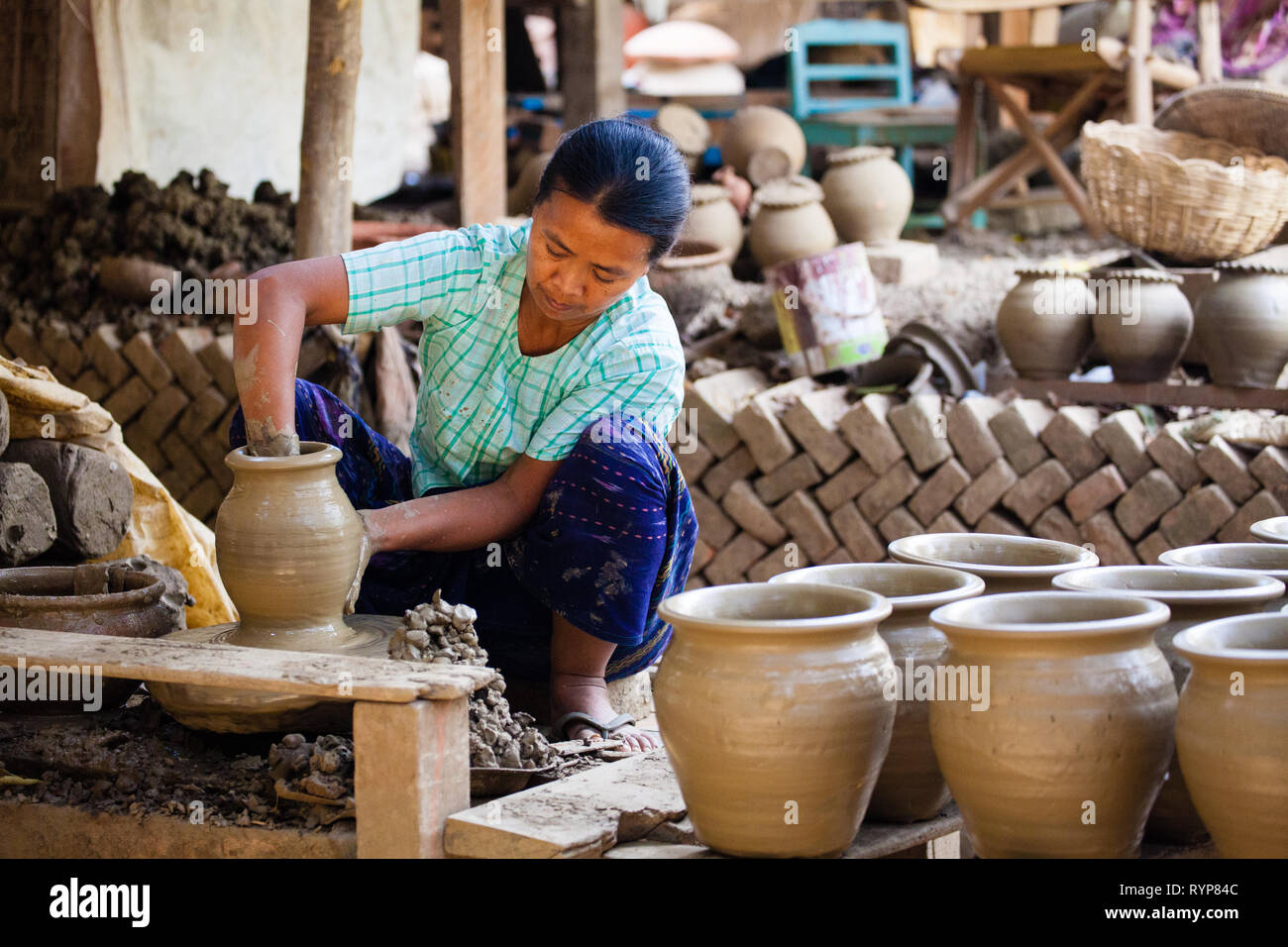 Un travailleur féminin fait des pots d'argile à Yandabo village potier au Myanmar Banque D'Images