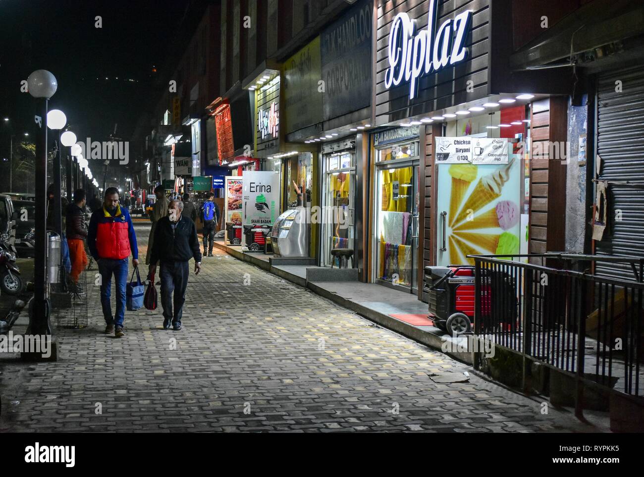 Vu les résidents à marcher le long de la rue pendant un temps le soir à Srinagar, au Cachemire. Le Cachemire est la région géographique la plus au nord du sous-continent indien. Il est en ce moment un territoire contesté, administré par trois pays : l'Inde, le Pakistan et la Chine. Banque D'Images