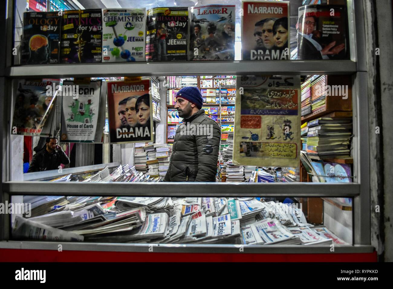 Un vendeur de journaux vu en attente de clients au cours du temps le soir à Srinagar, au Cachemire. Le Cachemire est la région géographique la plus au nord du sous-continent indien. Il est en ce moment un territoire contesté, administré par trois pays : l'Inde, le Pakistan et la Chine. Banque D'Images