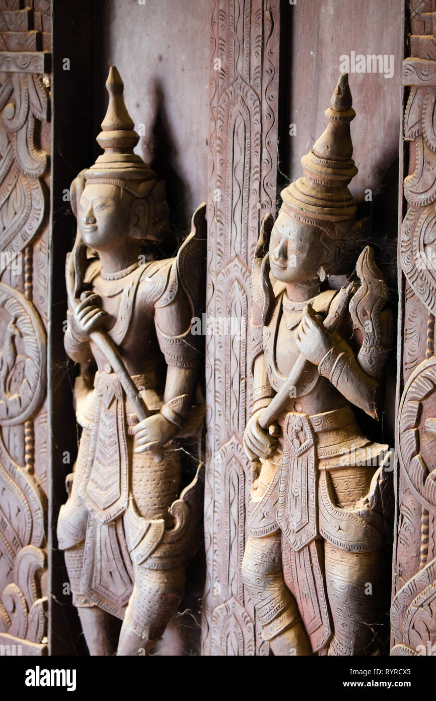 Sculptures de spiritueux à l'avant du monastère Shwe Inn Bin teak près de Mandalay en Birmanie Banque D'Images