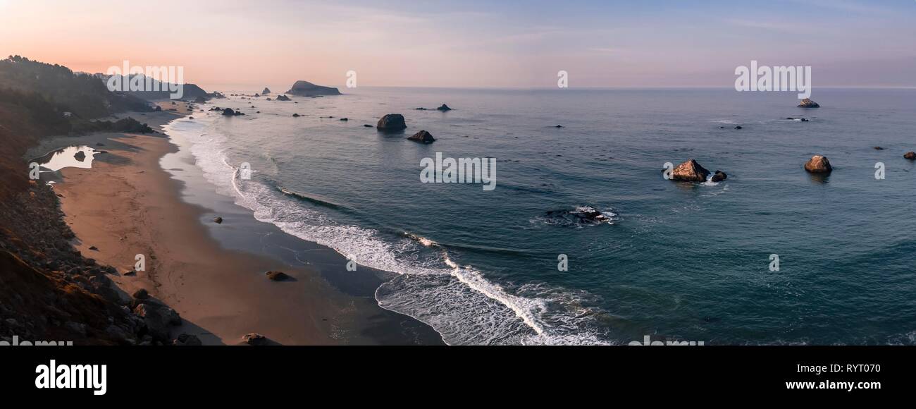 Le lever du soleil, plage de sable, Paysage côtier avec de nombreuses îles rocheuses, l'Oregon, USA Banque D'Images